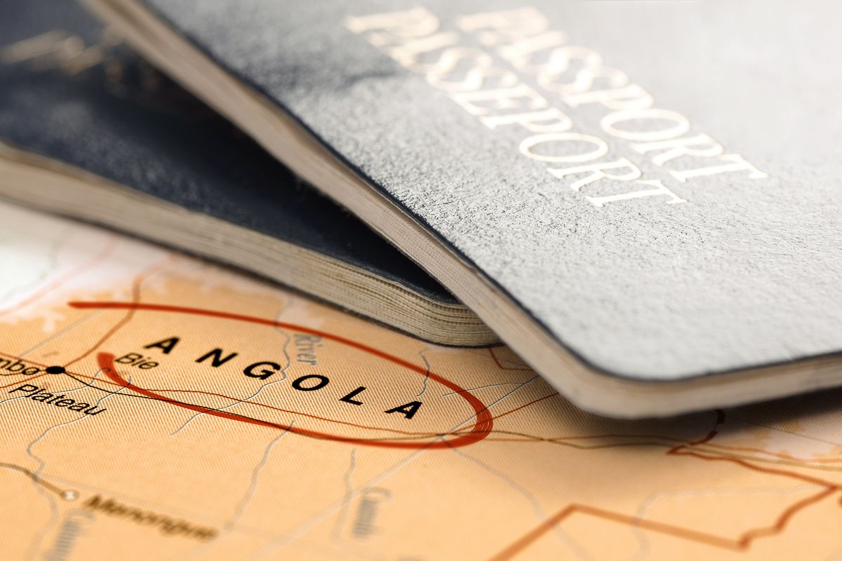 Destination Angola. Passports on the map. Travel concept.