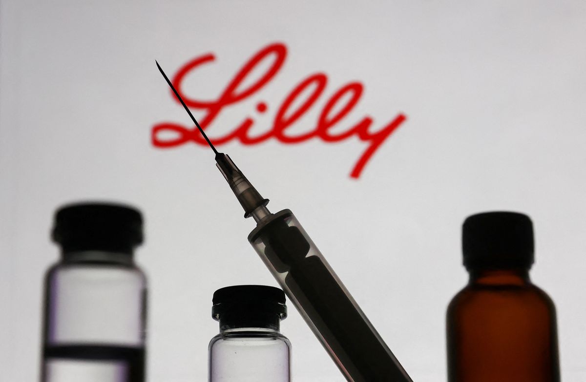 Medical bottles and syringe are seen with Eli Lilly and Company logo displayed on a screen in the background in this illustration photo taken in Krakow, Poland on November 10, 2022. (Photo by Jakub Porzycki/NurPhoto) (Photo by Jakub Porzycki / NurPhoto / NurPhoto via AFP)