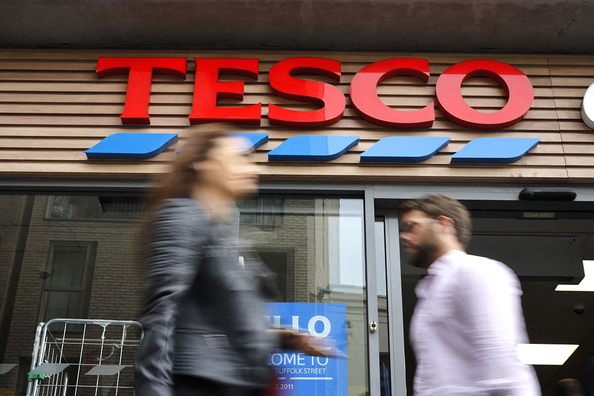 People walk past at a Tesco Express in central London on September 30, 2019. - Tesco, the Britain's biggest food retailer, will report its first-half results on October 2. (Photo by Tolga AKMEN / AFP)