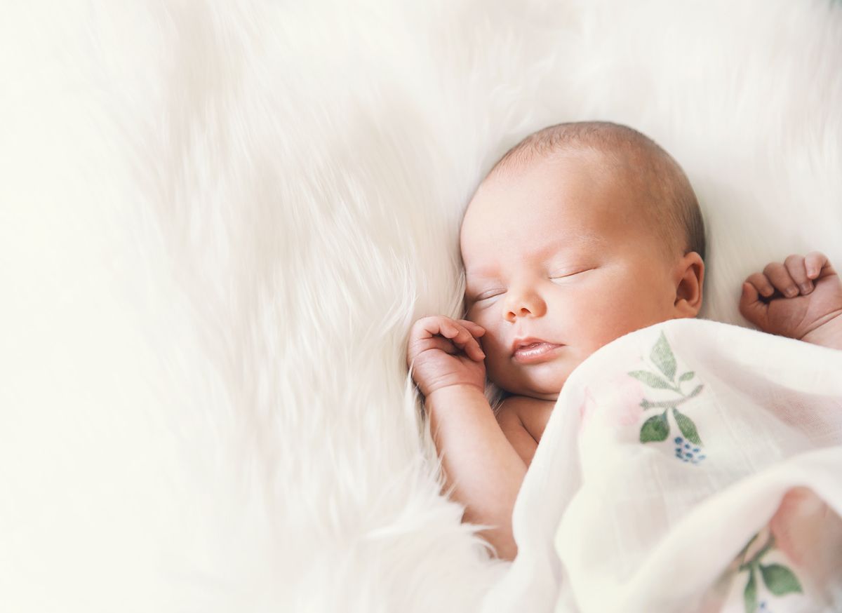 Sleeping,Newborn,Baby,In,A,Wrap,On,White,Blanket.,Beautiful