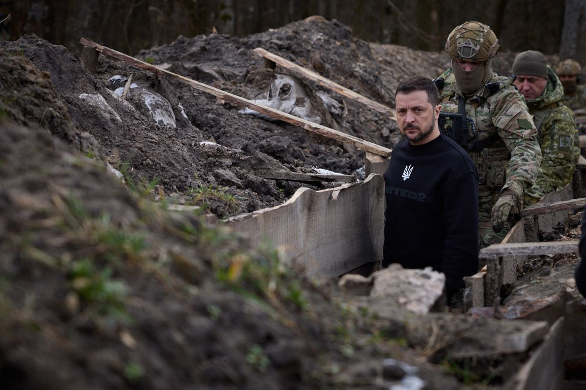 This handout photograph taken and released by Ukrainian Presidential Press Service on March 28, 2023 shows the President Volodymyr Zelensky walking along tranches with border guard officers as he inspects the state border with Russian Federation in Sumy region. 