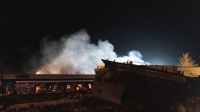 Lárisza, 2023. március 1.
Összeroncsolódott vasúti kocsi lángol a közép-görögországi Lárisza városa közelében, ahol összeütközött egy személyvonat és egy tehervonat 2023. március 1-re virradóra. Az ütközéstől több kocsi kisiklott, és lángba borult. A szerencsétlenségben legkevesebb 32-en életüket vesztették, 85-en megsérültek.