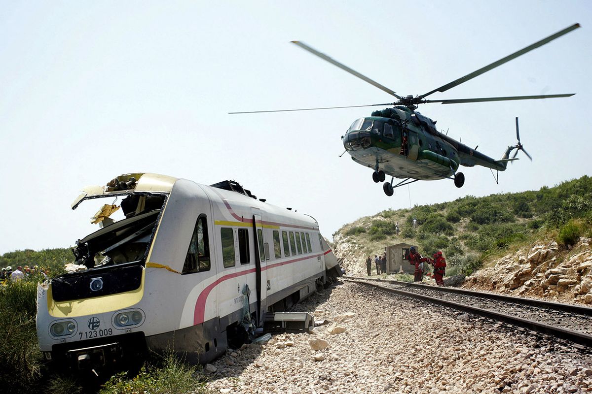 A rescue helicopter hovers above the wreckage of a derailed train at Kastel Stari, on July 24, 2009. A train derailed in Croatia, killing six people and injuring 20 on a route linking the capital and the central coastal town of Split, police said. The crash occurred near the town of Kastel Stari, outside Split, at 12:08 pm (1008 GMT) when the tilting train designed for faster travel on regular tracks flew off the rails, according to authorities. AFP PHOTO/ STR -    CROATIA OUT - (Photo by AFP)