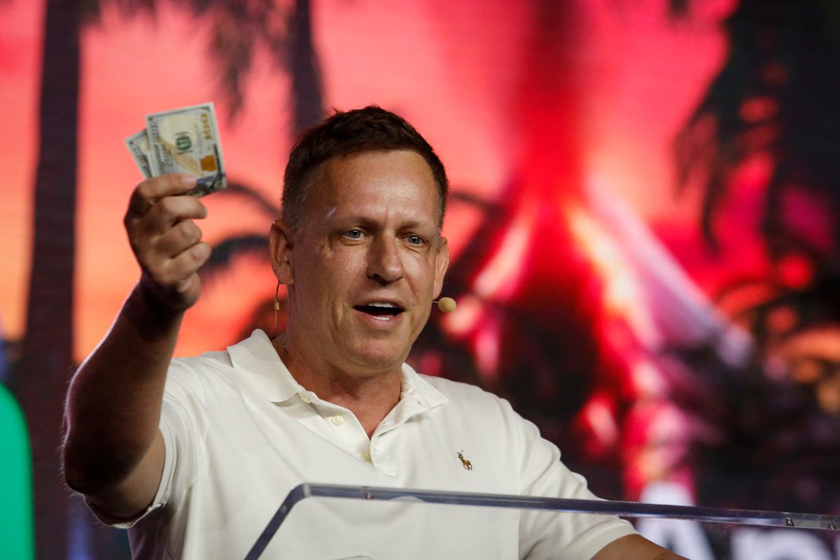 MIAMI, FLORIDA - APRIL 7:  Peter Thiel, co-founder of PayPal, Palantir Technologies, and Founders Fund, holds hundred dollar bills as he speaks during the Bitcoin 2022 Conference at Miami Beach Convention Center on April 7, 2022 in Miami, Florida. The worlds largest bitcoin conference runs from April 6-9, expecting over 30,000 people in attendance and over 7 million live stream viewers worldwide.