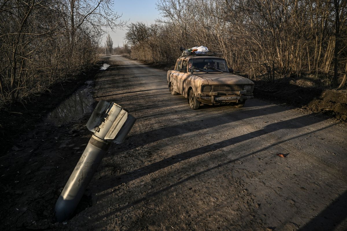 A vehicle drives past a nailed missile tail in the village of Chasiv Yar near Bakhmut, on March 14, 2023. (Photo by  / AFP)