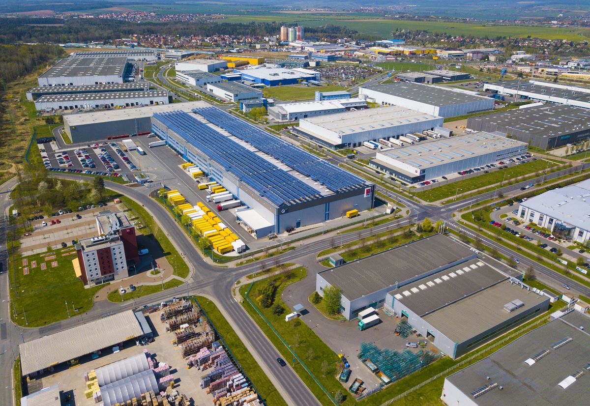 PILSEN, CZECH REPUBLIC - APRIL 19, 2018: Flight over modern storage warehouse with solar panels on the roof. Industrial zone and technology park on Bory suburb of Pilsen city, Czech Republic, Europe.