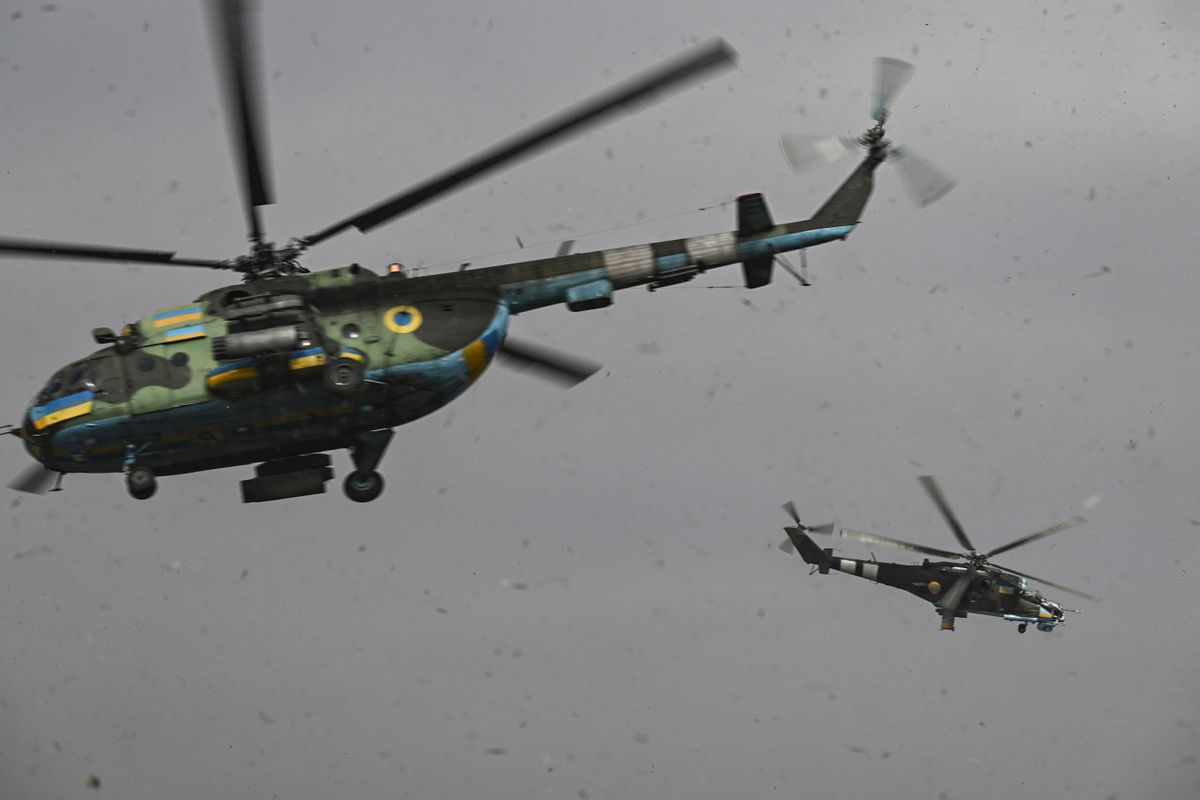An Mi-24 (R) and an Mi-8 (L) helicopters take off for a mission against Russian targets on March 26, 2023, amid the Russian invasion of Ukraine.