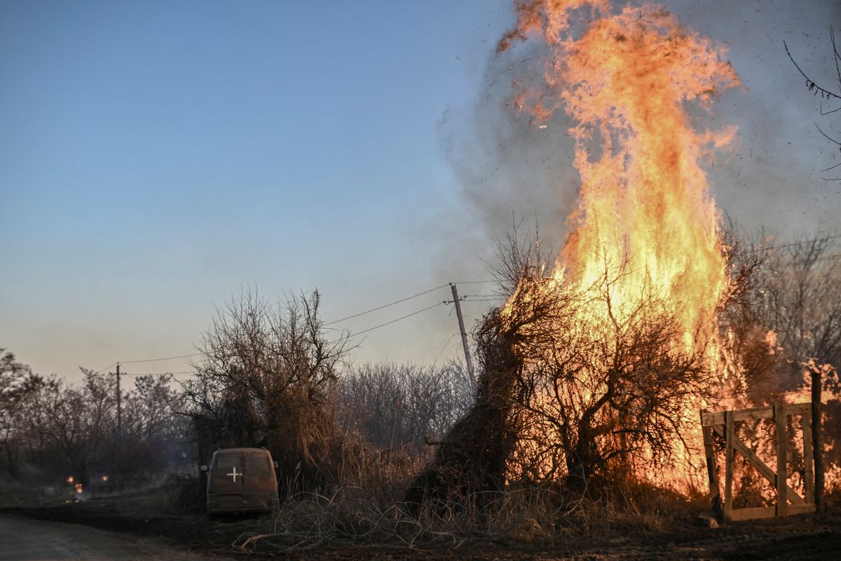 Trees burn next to a Ukrainian military vehicle, after white phosphorus munitions exploded in the air, at the village of Chasiv Yar near Bakhmut, on March 14, 2023, amid the Russian invasion of Ukraine.