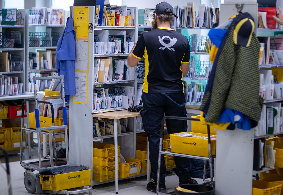 Letter carrier at the post office 07 August 2019, Mecklenburg-Western Pomerania, Wittenburg: Letter carriers sort the mail items for their tours together at the Deutsche Post parcel delivery base. Photo: Jens Büttner/dpa-Zentralbild/ZB (Photo by JENS BUTTNER / dpa-Zentralbild / dpa Picture-Alliance via AFP)
