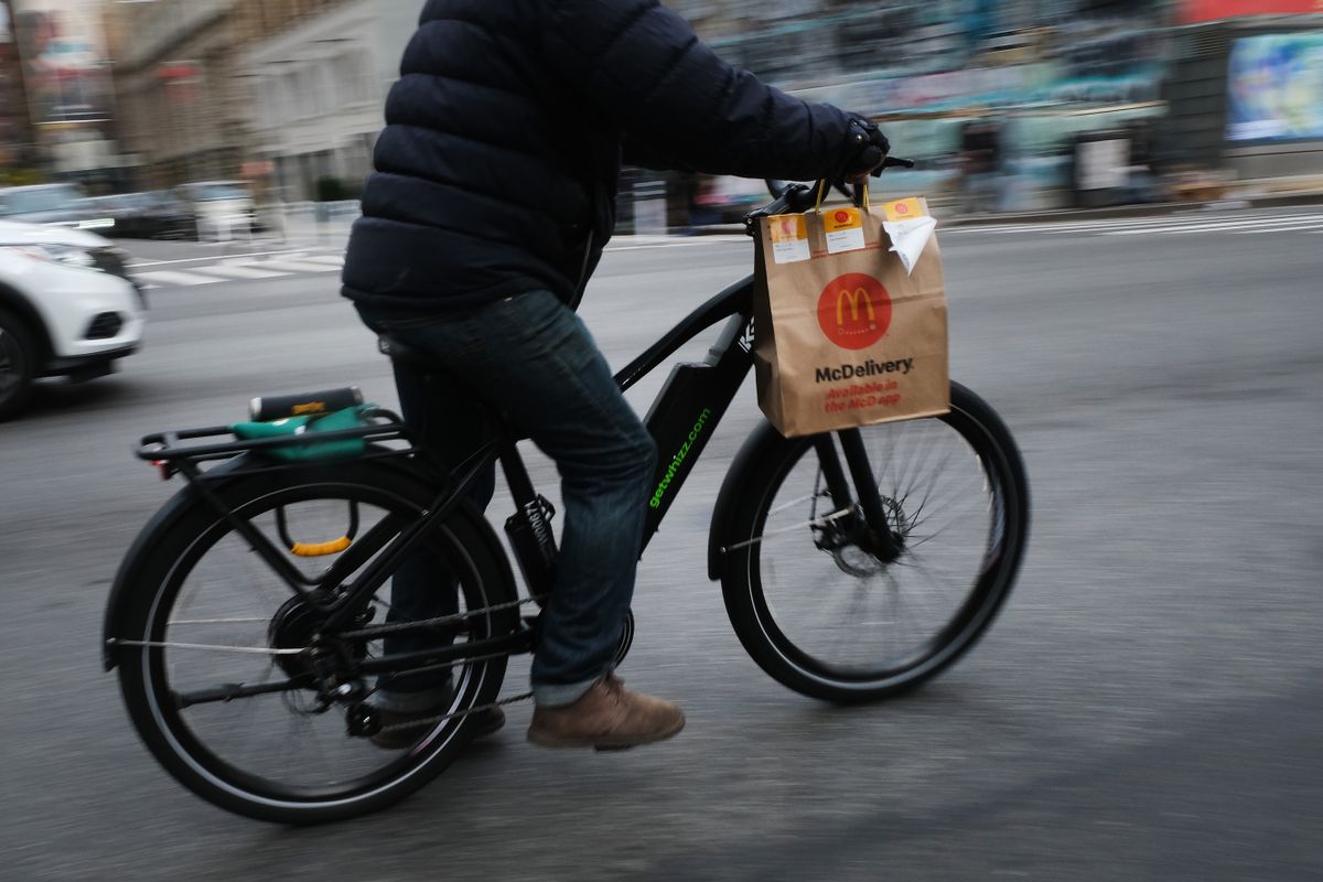 NEW YORK, NEW YORK - NOVEMBER 15: A delivery person rides an electric bicycle through the streets of Manhattan on November 15, 2022 in New York City. Electric bicycles, which have surged in popularity with both delivery workers and commuters, run on lithium-ion batteries which can be combustible when charging, especially cheaper models. Some New York City landlords are banning electric bicycles from their buildings following a series of fires, one in Manhattan this month which sent 43 people to the hospital after a faulty bike battery left charging by a tenant caught fire.