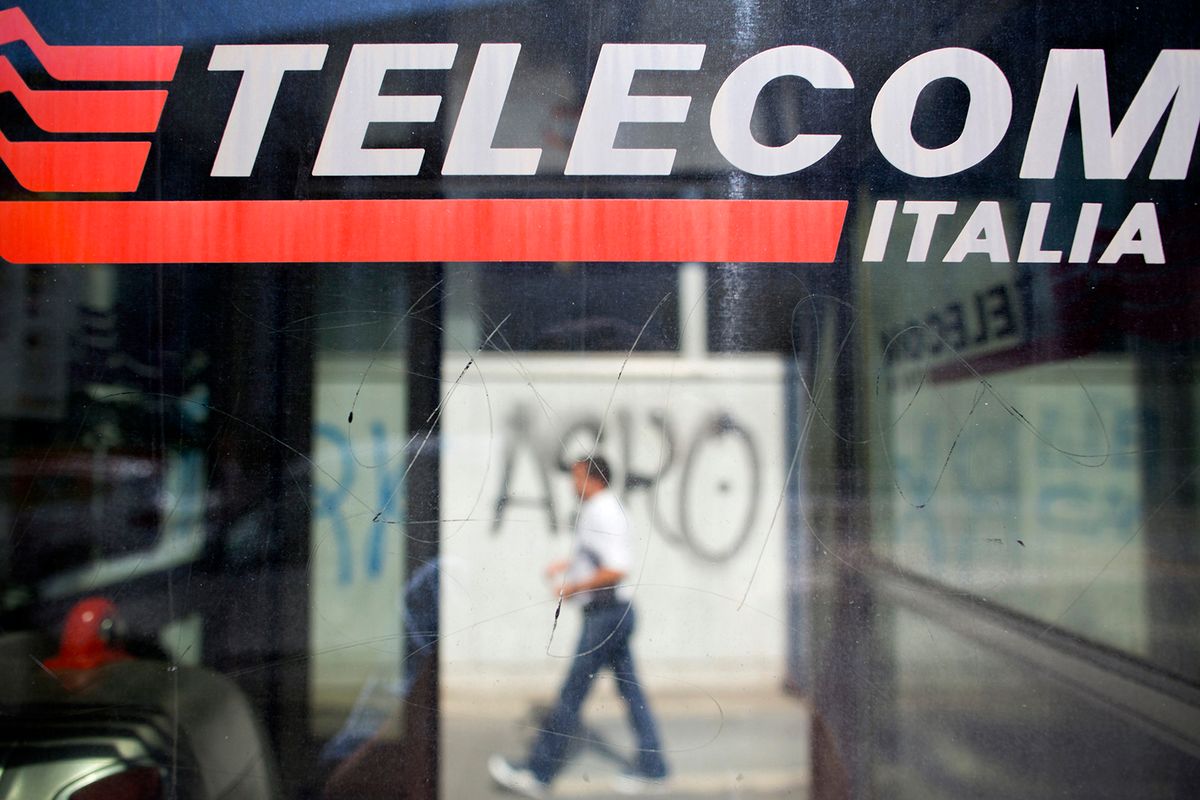 Telecom Italia SpA Stores And Fixed-Line Phones As Vivendi SA Investment Is Company's First Step To Building Media Group A pedestrian passes a Telecom Italia SpA public phone box in Milan, Italy, on Monday, Sept. 7, 2015. Vivendi SA's investment in Telecom Italia SpA is the French company's first step in building a media group with a distinct focus in southern Europe, according to its chief executive officer, who doesnt rule out further boosting its stake in Italy's largest telecommunications provider. Photographer: Jason Alden/Bloomberg via Getty Images