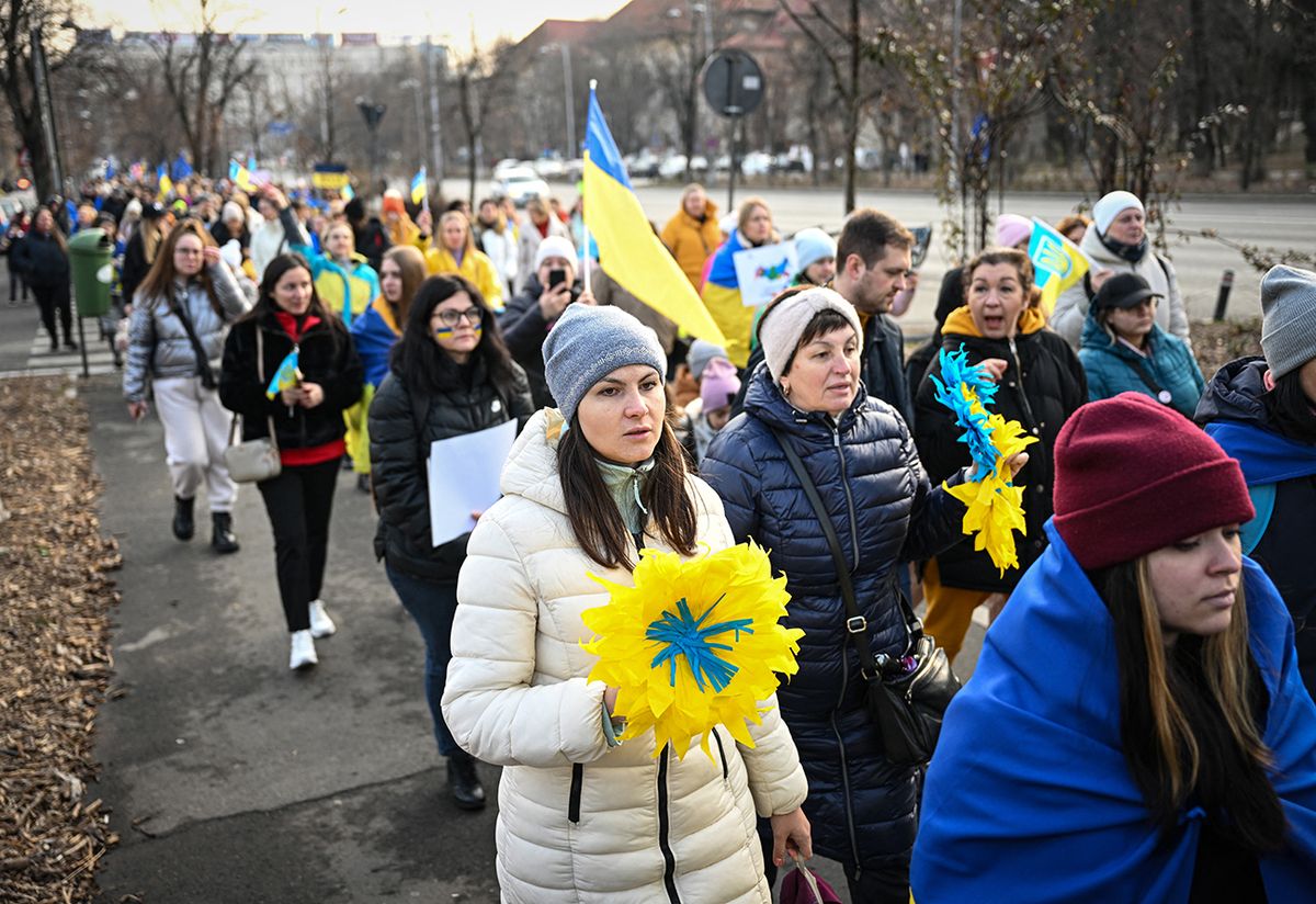 Ukrainian refugees take part in a march marking the first anniversary of the Russian invasion of Ukraine in Bucharest, Romania on February 24, 2023. - Hundreds of Ukrainians took part in a march starting from Romanian Government headquarters towards the Russian Embassy to Bucharest calling for the stop of the war and commemorating the victims of it. (Photo by Daniel MIHAILESCU / AFP)