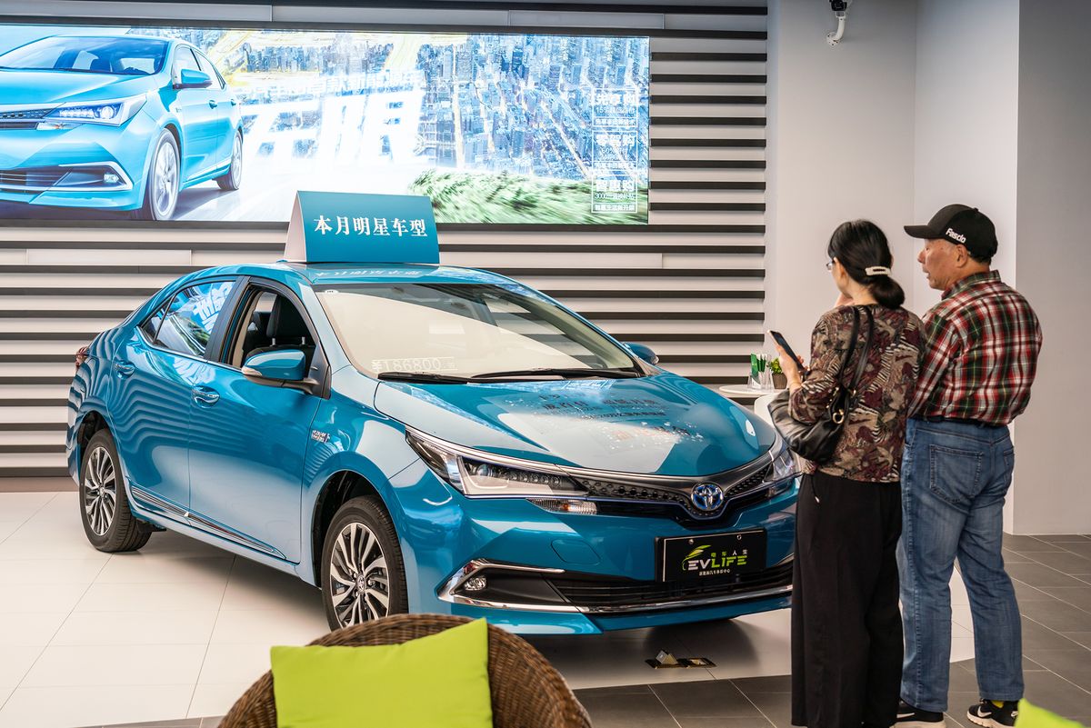 Customers look at a Toyota Levin plug-in hybrid electric