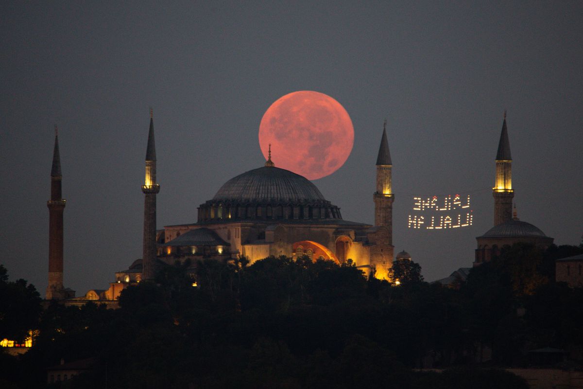 ISTANBUL, TURKEY - AUGUST 11: The Super Moon sinks behind the Hagia Sophia Mosque on August 11, 2022 in Istanbul, Turkey.  