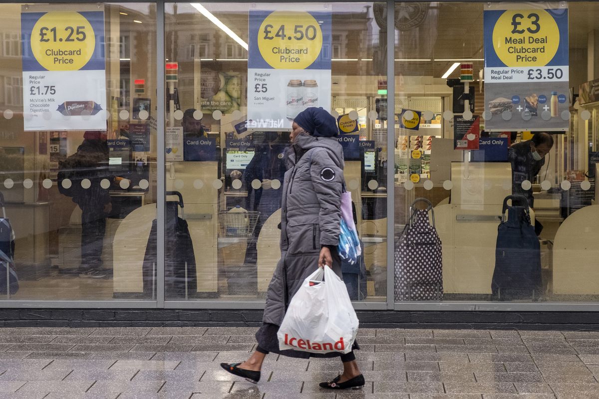 LONDON, UNITED KINGDOM - OCTOBER 20: A woman carrying a shopping bag walks past a Tesco supermarket as the UK inflation rises to 10.1% due to rising food prices in London, United Kingdom on October 20, 2022. 