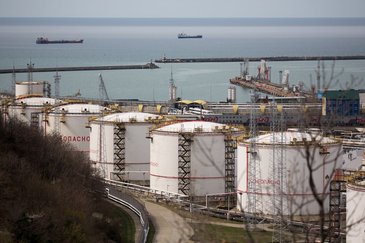 Oil storage tanks stand at the RN-Tuapsinsky refinery, operated by Rosneft Oil Co., as tankers sail beyond in Tuapse, Russia, on Monday, March 23, 2020. Major oil currencies have fallen much more this month following the plunge in Brent crude prices to less than $30 a barrel, with Russias ruble down by 15%.  