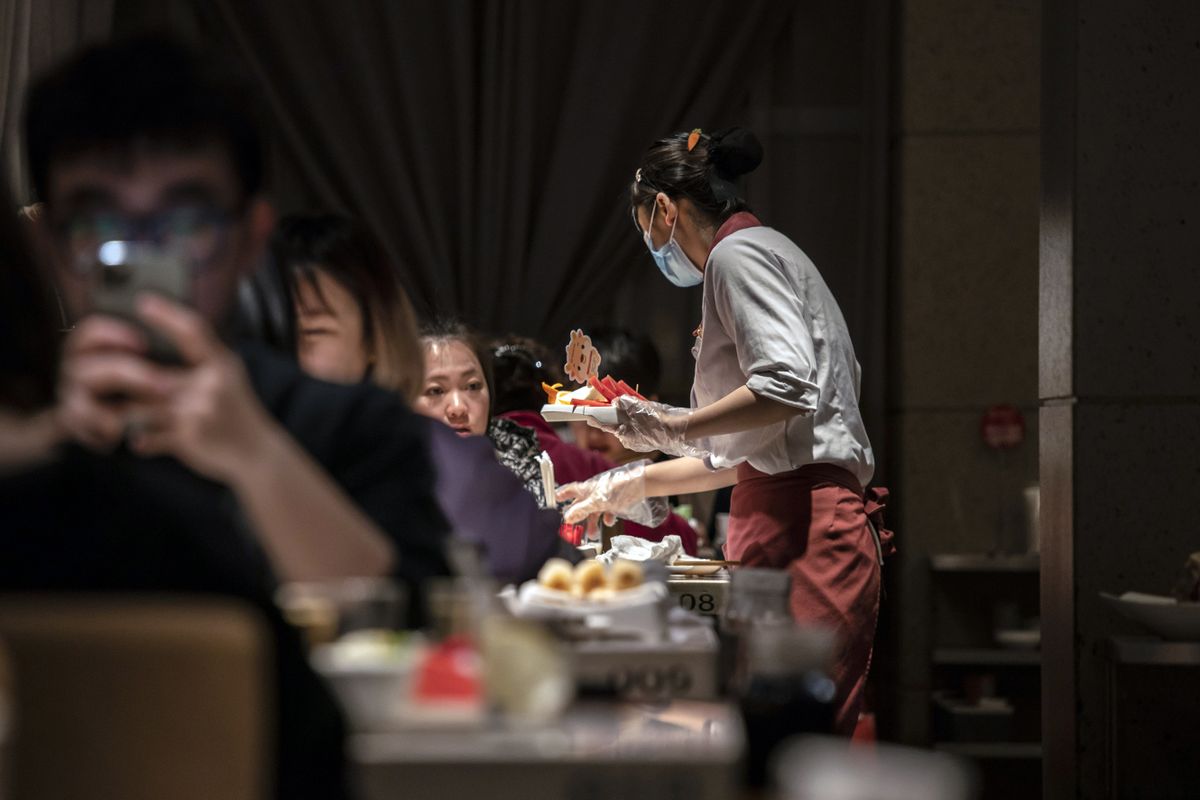 An employee serves a dish inside a Haidilao hotpot restaurant, operated by Haidilao International Holding Ltd., in Shanghai, China, on Wednesday, April 7, 2021. China is scheduled to release consumer price index (CPI) figures on April 9. 