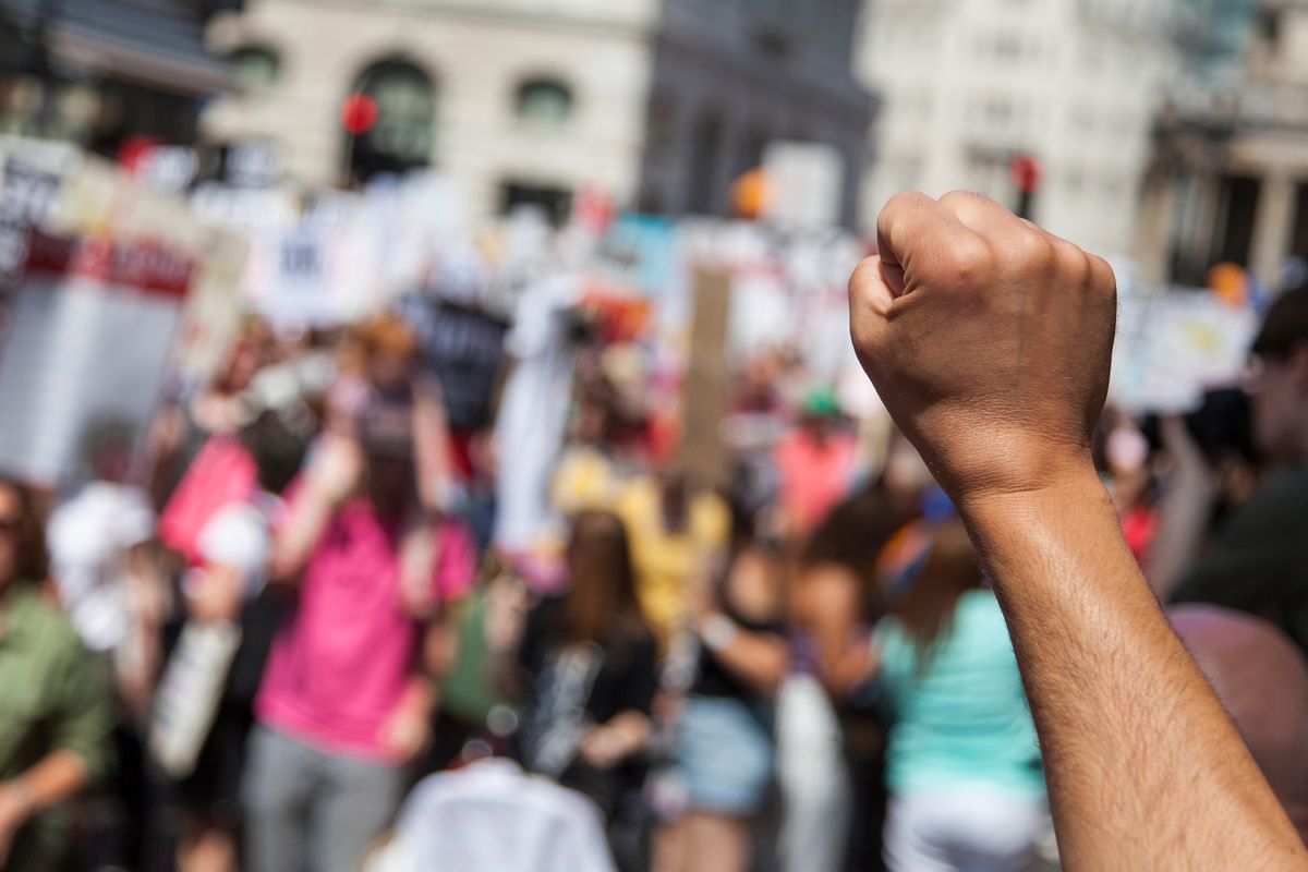 A,Raised,Fist,Of,A,Protestor,At,A,Political,Demonstration