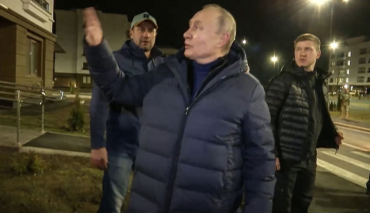 This handout video grab released by Russian Presidential Press Office on March 19, 2023, shows Russian President Vladimir Putin speaking with people at a newly built neighborhood during his visit to Mariupol in Russian-controlled Donetsk region. - Russian President Vladimir Putin made a surprise trip to Mariupol, the Kremlin said, his first visit to territory captured from Ukraine since the start of Moscow's offensive. Just hours after Putin visited Crimea to mark the ninth anniversary of the peninsula's annexation, video distributed by the Kremlin showed him landing by helicopter in Mariupol, the port city that Moscow captured after a long siege last spring. 