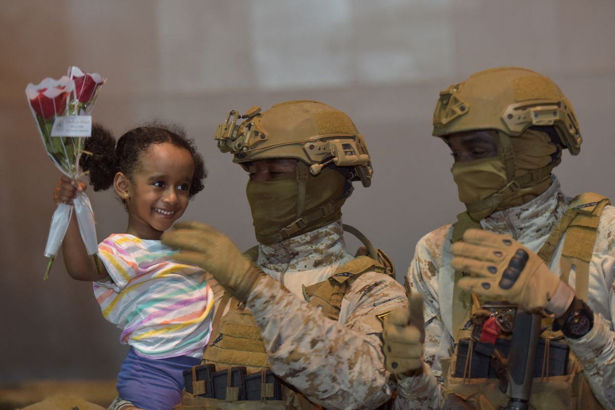 A member of the Saudi armed forces carries a girl who arrived at King Faisal navy base in Jeddah, following a rescue operation from Sudan. - A ship carrying some 200 Saudi citizens and 14 other nationalities rescued from battle-scarred Sudan arrived in Jeddah, Saudi television said.