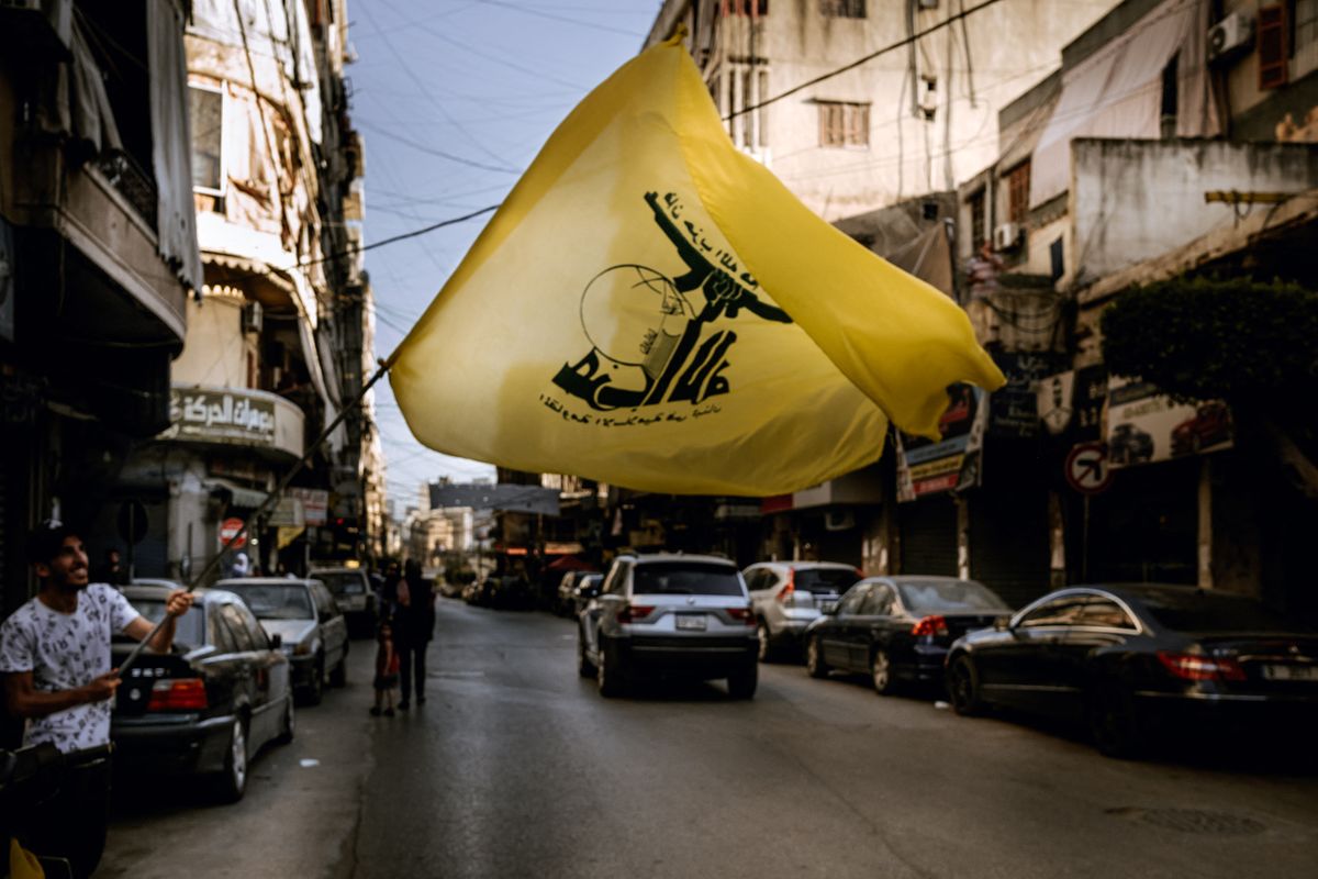 Lebanon, Beirut, 2022-05-15. In a street of Dahieh (Dahye), a Shiite Muslim suburb, a man holds up a large Hezbollah flag. Located in the south of the capital, this neighborhood of the Baabda district is very much in favor of the Amal and Hezbollah parties. Today the Lebanese went to the polls for the first time since the protest movement of 2019. Karine Pierre / Hans Lucas Agency.Liban, Beyrouth, 2022-05-15. Dans une rue du quartier de Dahieh (Dahye), banlieue musulmane chiite, un homme brandit un grand drapeau du Hezbollah. Situe au sud de la capitale, ce quartier du district de Baabda est tres largement acquis a la cause des parties Amal et Hezbollah. Aujourd’hui, les Libanais se sont rendus aux urnes pour la premiere fois depuis le mouvement de protestation de 2019. Karine Pierre / Agence Hans Lucas.