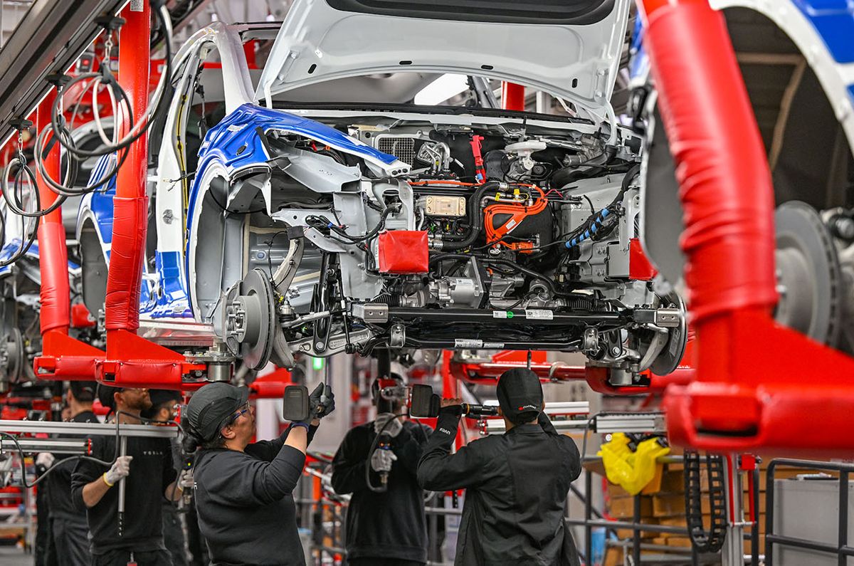 One year Tesla Gigafactory Berlin Brandenburg
One year Tesla Gigafactory Berlin Brandenburg
20 March 2023, Brandenburg, Grünheide: Employees of the Tesla Gigafactory Berlin Brandenburg work on a production line of a Model Y electric vehicle. The Tesla plant was opened and put into operation on March 22, 2022. In the meantime, about 10,000 people are employed there. (to dpa "One year of Tesla plant in Germany - showcase factory and object of dispute") Photo: Patrick Pleul/dpa (Photo by PATRICK PLEUL / DPA / dpa Picture-Alliance via AFP)
