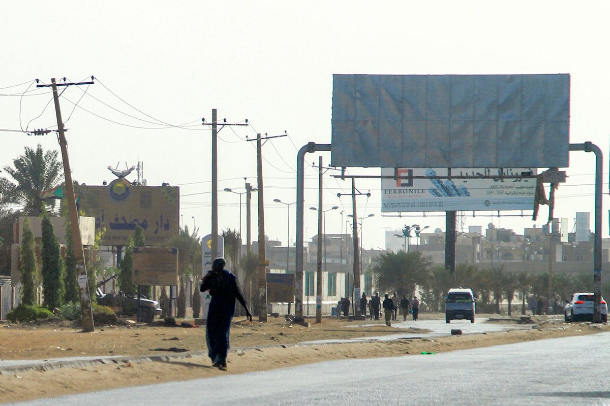 A man walks along a road near a "technical" vehicle (pickup truck mounted with turret) of Sudan's Rapid Support Forces (RSF) paramilitaries stationed outside the offices of Dar al-Mushaf (African Holy Koran Publishing House), in the south of Sudan's capital Khartoum on April 17, 2023. 