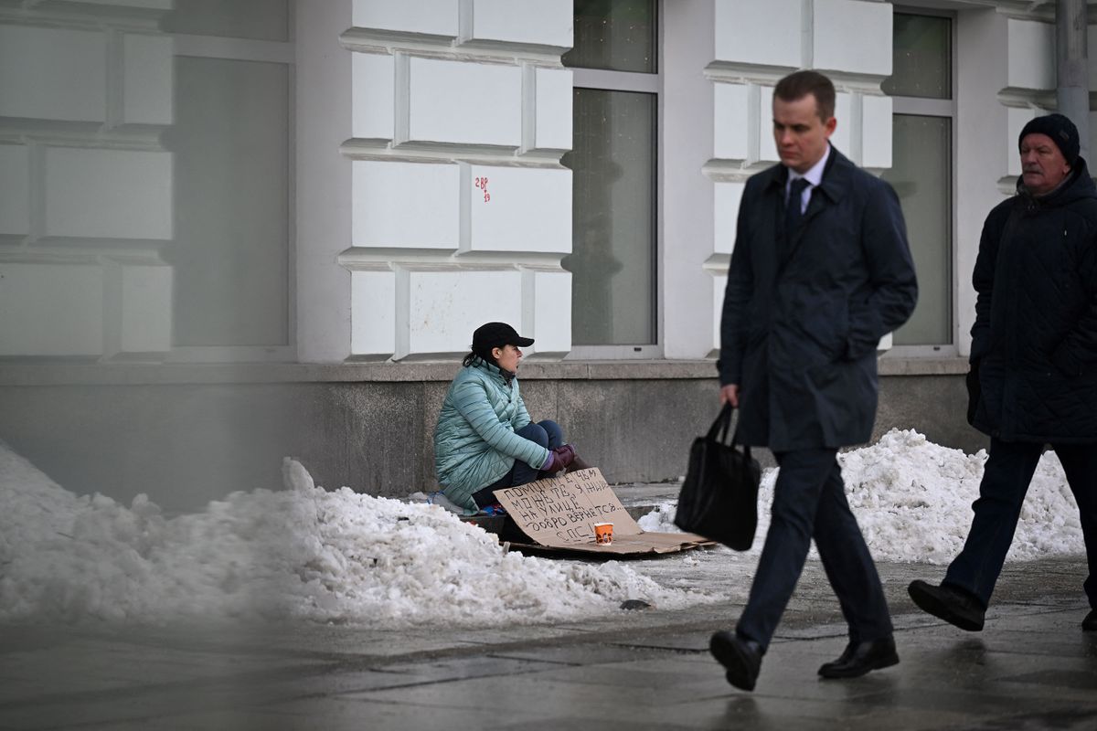 A woman begs for money on a street in Moscow on March 10, 2023. (Photo by Natalia KOLESNIKOVA / AFP)