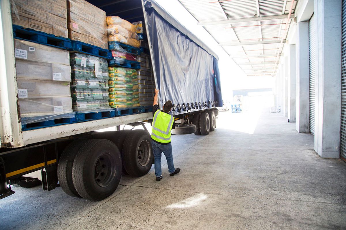 Worker loading a lorry at a large warehouse Worker loading a lorry at a large warehouse, eyport, imsport, raktár, kamion, áru, dobozok, rakodás, rakodó
külker, KSH