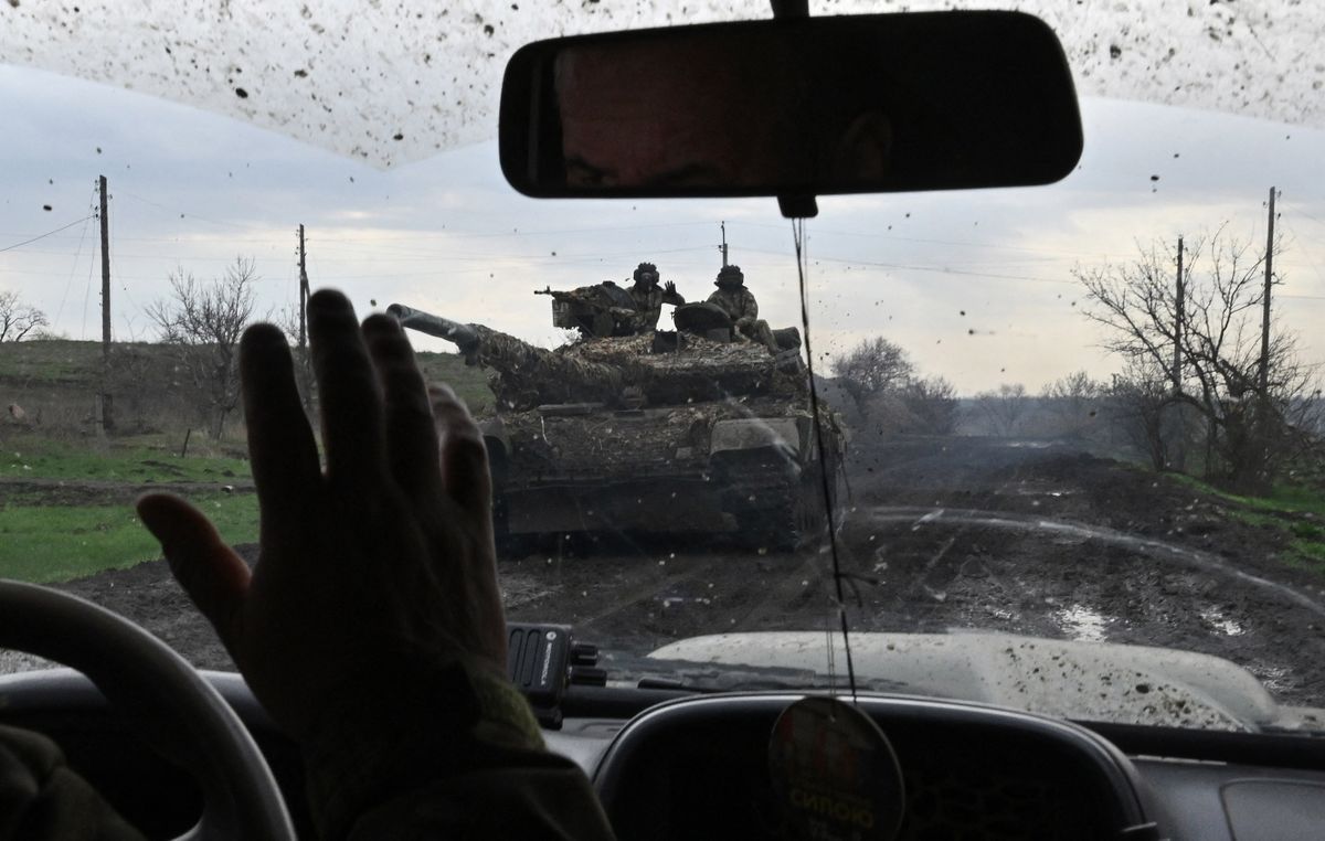 Ukrainian servicemen greets each other as they drive along a road near the town of Bakhmut, Donetsk region on April 8, 2023, amid the Russian invasion of Ukraine. - Bakhmut has become the longest and bloodiest battle in Ukraine. Both sides have endured heavy losses in the eastern industrial city, home to around 70,000 people before the war