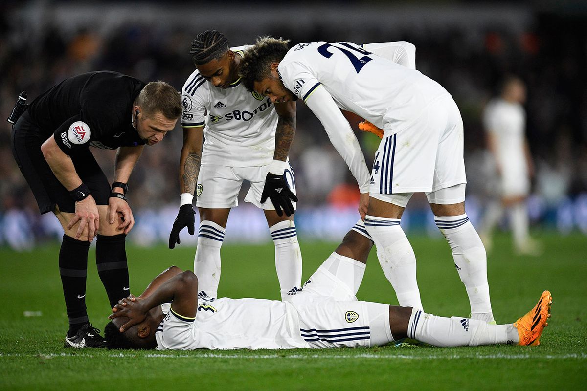 Leeds United's Colombian striker Luis Sinisterra (C) is helped after picking up an injury during the English Premier League football match between Leeds United and Liverpool at Elland Road in Leeds, northern England on April 17, 2023. (Photo by Oli SCARFF / AFP) / RESTRICTED TO EDITORIAL USE. No use with unauthorized audio, video, data, fixture lists, club/league logos or 'live' services. Online in-match use limited to 120 images. An additional 40 images may be used in extra time. No video emulation. Social media in-match use limited to 120 images. An additional 40 images may be used in extra time. No use in betting publications, games or single club/league/player publications. /
FBL-ENG-PR-LEEDS-LIVERPOOL
