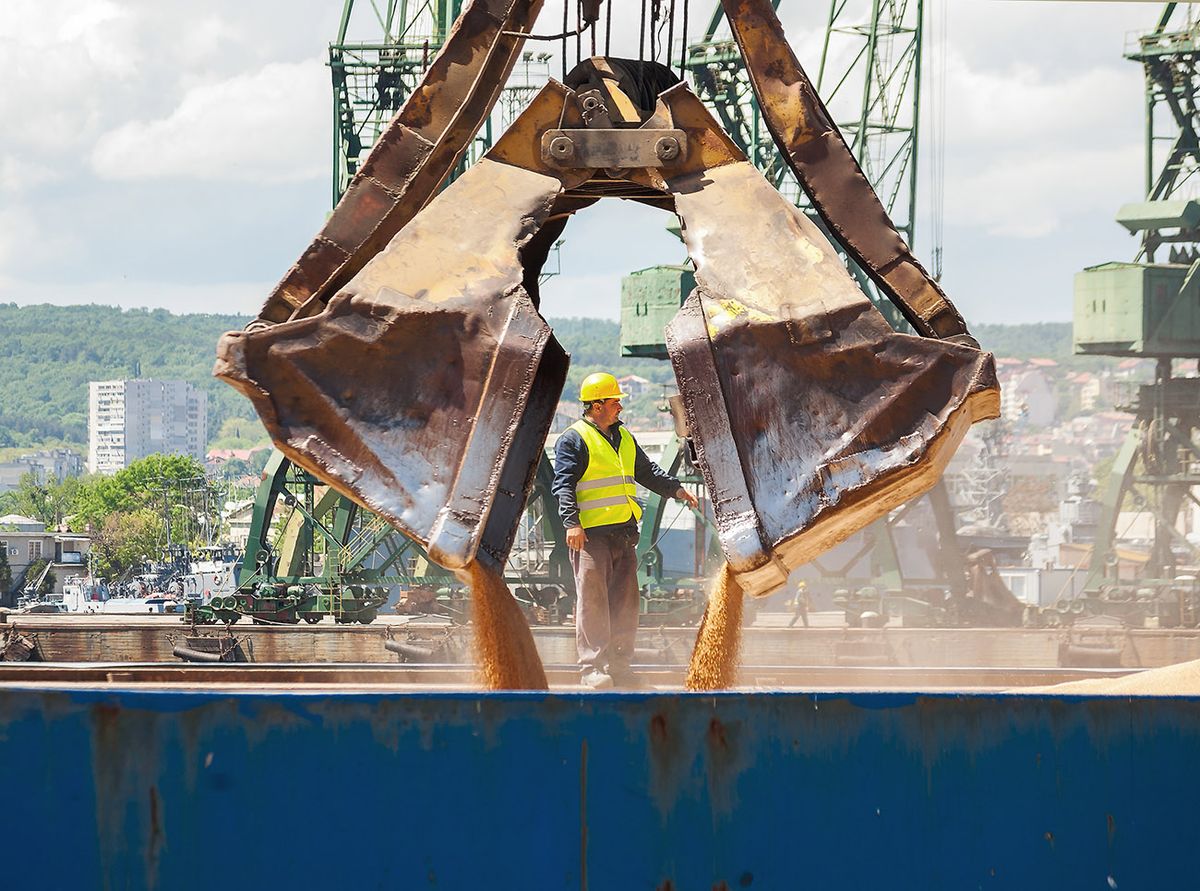 Massive,Scoop,,Part,Of,A,Port,Crane,,Is,Navigated,From
Massive scoop, part of a port crane, is navigated from worker while loading ship with wheat at Varna port, Varna, Bulgaria, May 16, 2015.