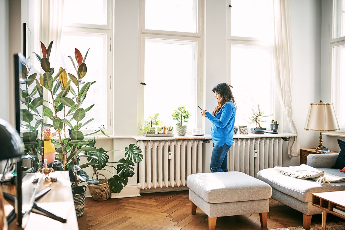 Woman using mobile phone in living room
Side view of woman using smart phone. Female is standing by window in living room. She is at home.
MVM távhő