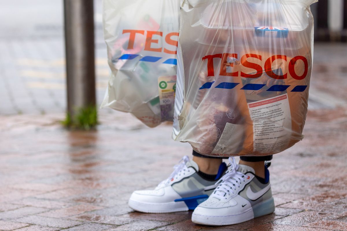 A shopper holds bags outside a Tesco Plc supermarket in Guildford, UK, on Tuesday, Jan. 10, 2023. Tesco are due to release a trading update on Thursday. 