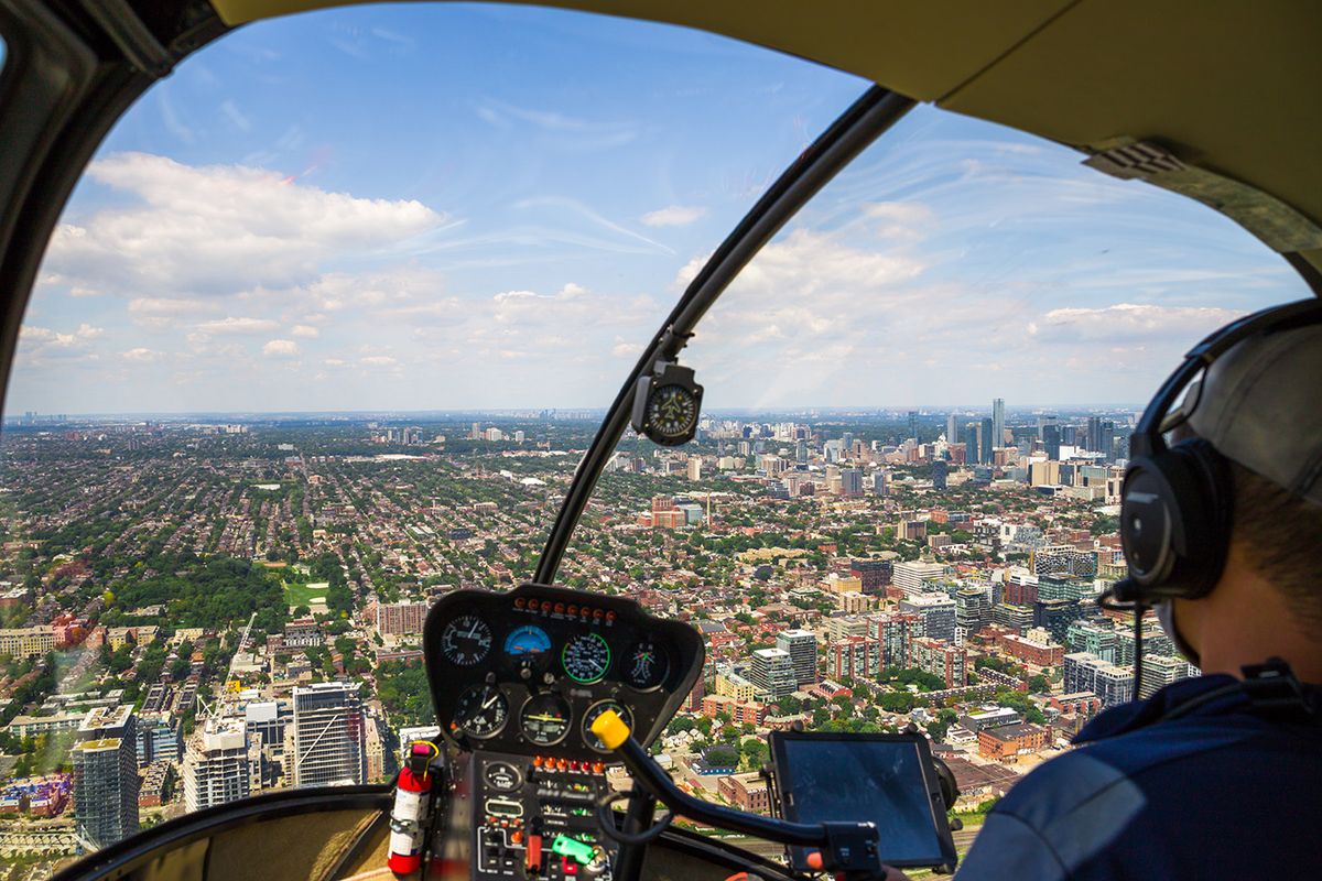 Helicopter,Cockpit,Flies,In,Toronto,City,Downtown,,With,Pilot,Arm
Helicopter cockpit flies in Toronto city downtown, with pilot arm and control board inside the cabin. 