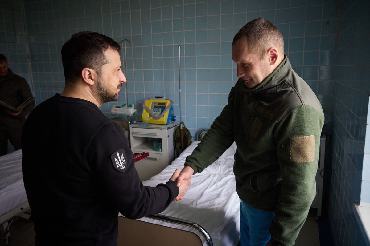 This handout picture taken and released by Ukrainian presidential press service on April 18, 2023 shows Ukrainian president Volodymyr Zelensky (L) awarding a wounded serviceman at the military hospital of the heavily shelled frontline in the Donetsk region, amid Russian invasion of Ukraine.