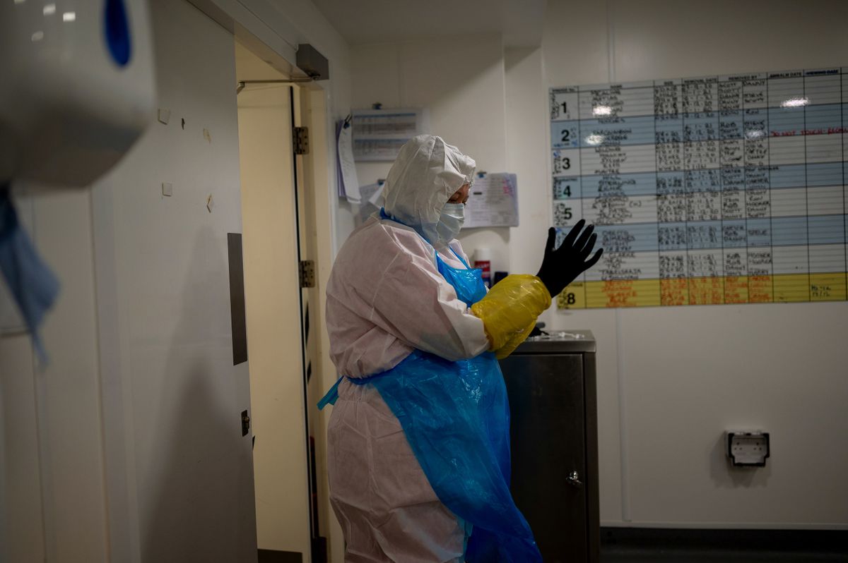 CROYDON, ENGLAND - JANUARY 13: Sophie Watkinson, 33, prepares to embalm a COVID-19 victim by donning full personal protective equipment at the Rowland Brothers funeral home on January 13, 2021 in Croydon, south of London, United Kingdom. Staff of the Rowland Brothers are preparing for an uptick in numbers based on current numbers of critical COVID-19 patients in intensive care units in and around London. For the past sever days, at least one thousand COVID-related deaths have been recorded daily. 