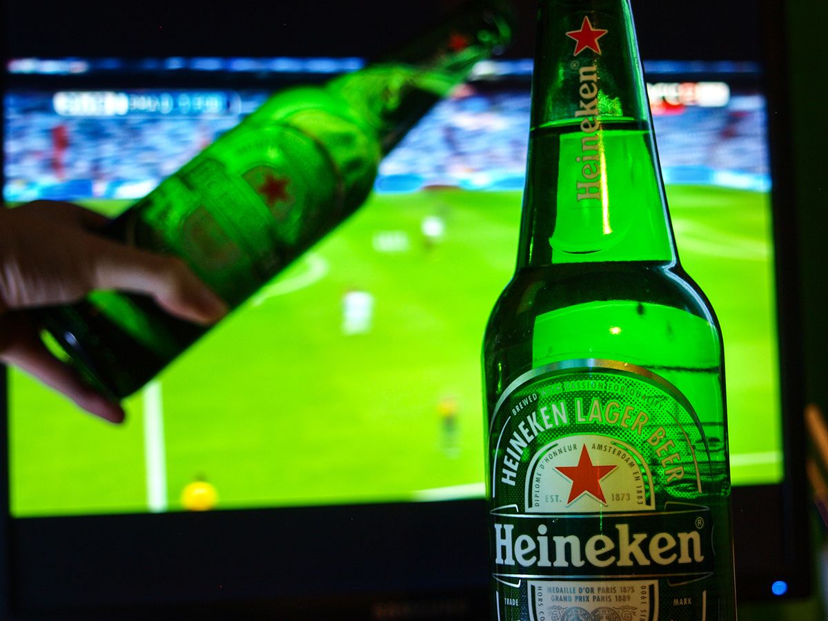 Vecsă©s,,Hungary,-,January,19,,2018:,Heineken,Glass,Hand,Over,
Vecsés, Hungary - January 19, 2018: Heineken glass hand over, in the background football game.