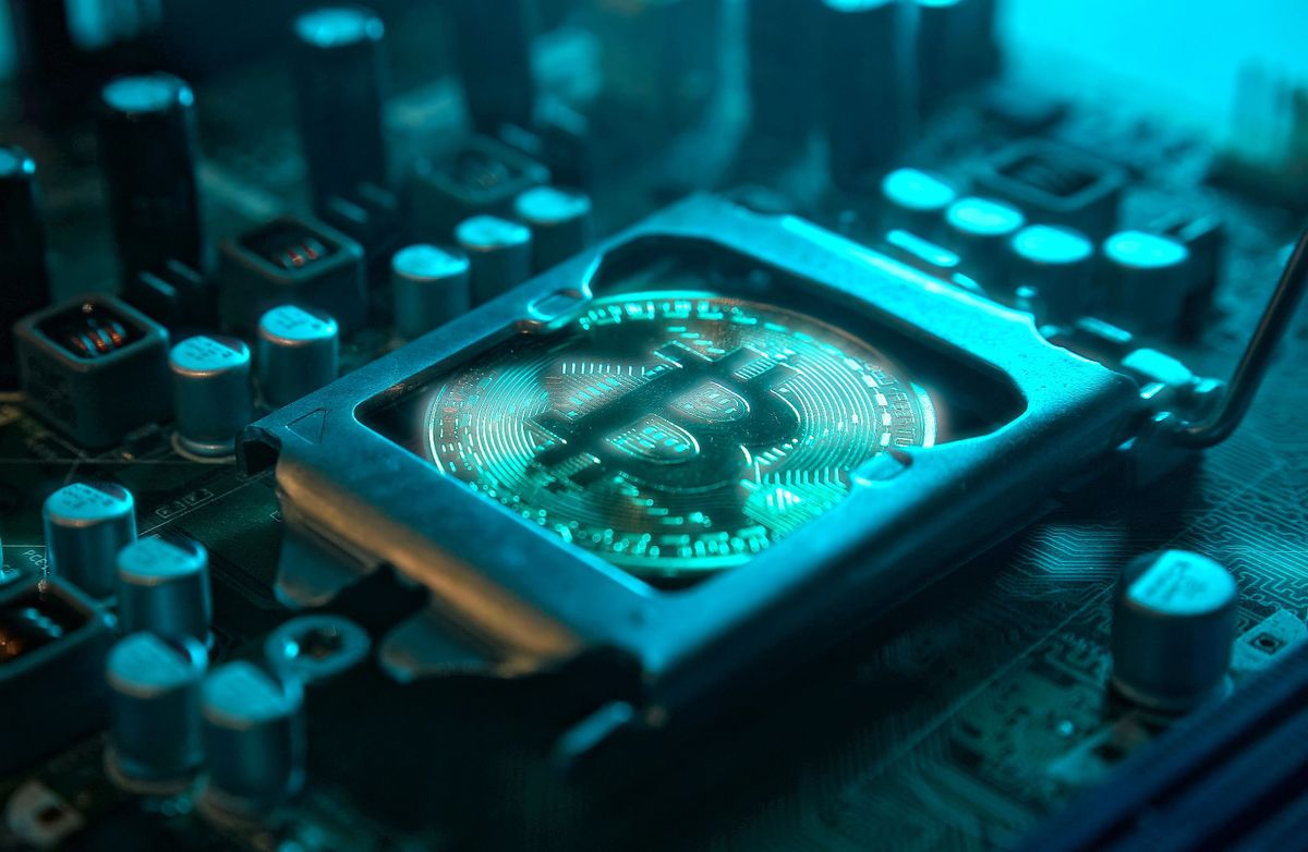 A,Gold,Bitcoin,Coin,With,Glare,And,Reflection,Installed,Instead
A gold Bitcoin coin with glare and reflection installed instead of a central processor in the motherboard with electronic components with blue light and smoke in the darkness. Bitcoin Mining