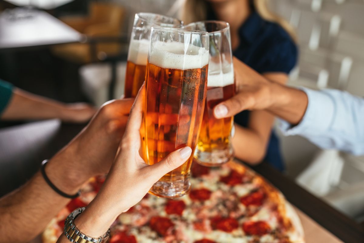 Close,Up,Shot,Of,Glasses,Of,Beer,And,Pizza