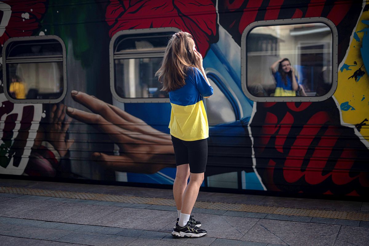 'Train To Victory' Project Tells Stories Of Ukrainians Living In Occupied Territory KYIV, UKRAINE - AUGUST 23: A young woman wearing a T-shirt in the colors of the Ukrainian national flag talks on the phone by one of the train cars of the "Train to Victory" on August 23, 2022 in Kyiv, Ukraine. The "Train to Victory" project, which will travel to different parts of the country, features seven train cars painted by Ukrainian artists, with each car telling stories of people resisting Russian forces. Tomorrow marks six months since Russia launched its large-scale invasion of Ukraine. (Photo by Alexey Furman/Getty Images)
Ukrajna utazás roaming