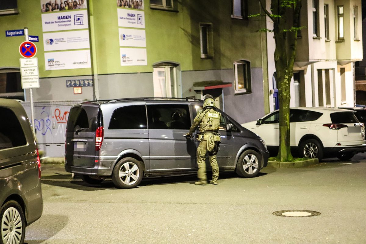 03 May 2023, North Rhine-Westphalia, Hagen: A police officer stands by a van during a raid. With a large-scale operation in several German states, the police took action against members of the Italian Mafia 'Ndrangheta on Wednesday. More than 1000 officers were deployed across Germany, including special forces.     (to dpa "More than 1000 officers in action: Strike against 'Ndrangheta in Germany") Photo: Alex Talash/dpa - ATTENTION: The license plate of the vehicle was pixelated for legal reasons 
