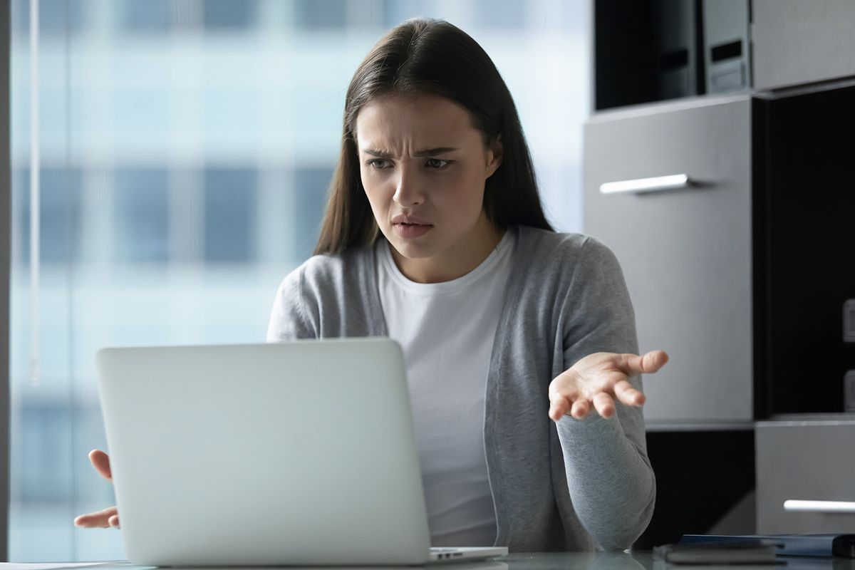 Unexpected trouble. Annoyed nervous millennial woman secretary employee office manager sitting by computer screen receiving email with bad news making critical mistake having problems with connection