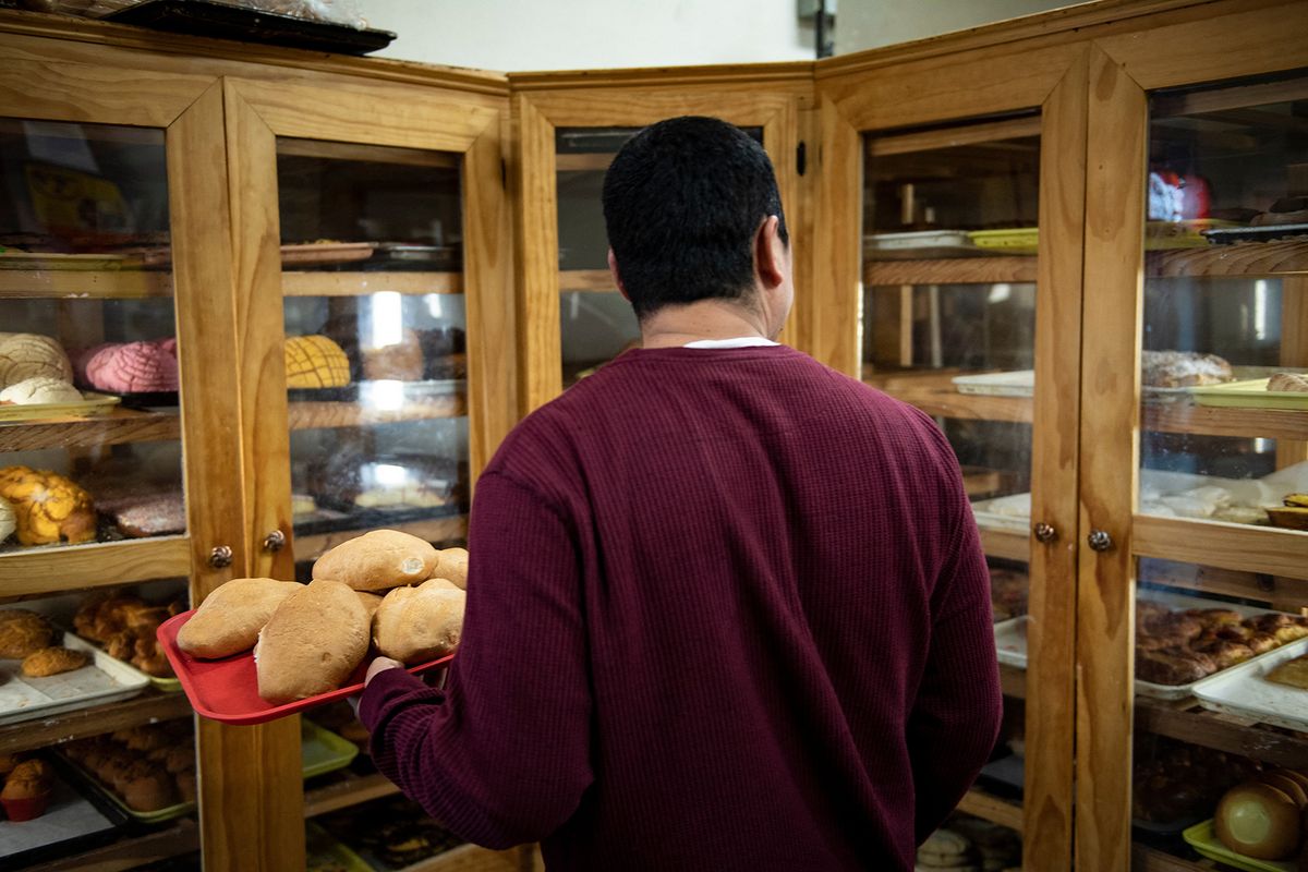A man selects pastries at the Acapulco Mexican Bakery & Grocery January 25, 2020 in West Liberty, Iowa. At the Catholic church in the small Iowa meatpacking town of West Liberty, the surrounding expanses of farmland covered with fresh white snow, the priest says Mass twice on Sunday.The two sermons' messages of harmony are similar, as is the 100-plus attendance, although it feels a notch more crowded at the second Mass -- offered in Spanish in this Midwestern state's first Latino-majority town. (Photo by Brendan Smialowski / AFP) / TO GO WITH AFP STORY BY  Shaun Tandon " In deep-white Iowa, first Latino-majority town shows future"