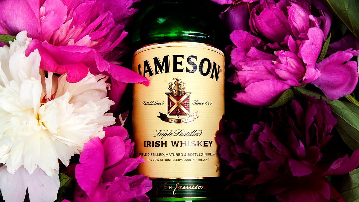Lviv,/,Ukraine,-,06.09.2020:,Banner,Of,A,Large,Bottle Lviv / Ukraine - 06.09.2020: Banner of a large bottle of Irish whiskey Jameson 700 ml lies on a white wooden table on spring-summer flowers, with space for text, from close range, no people.