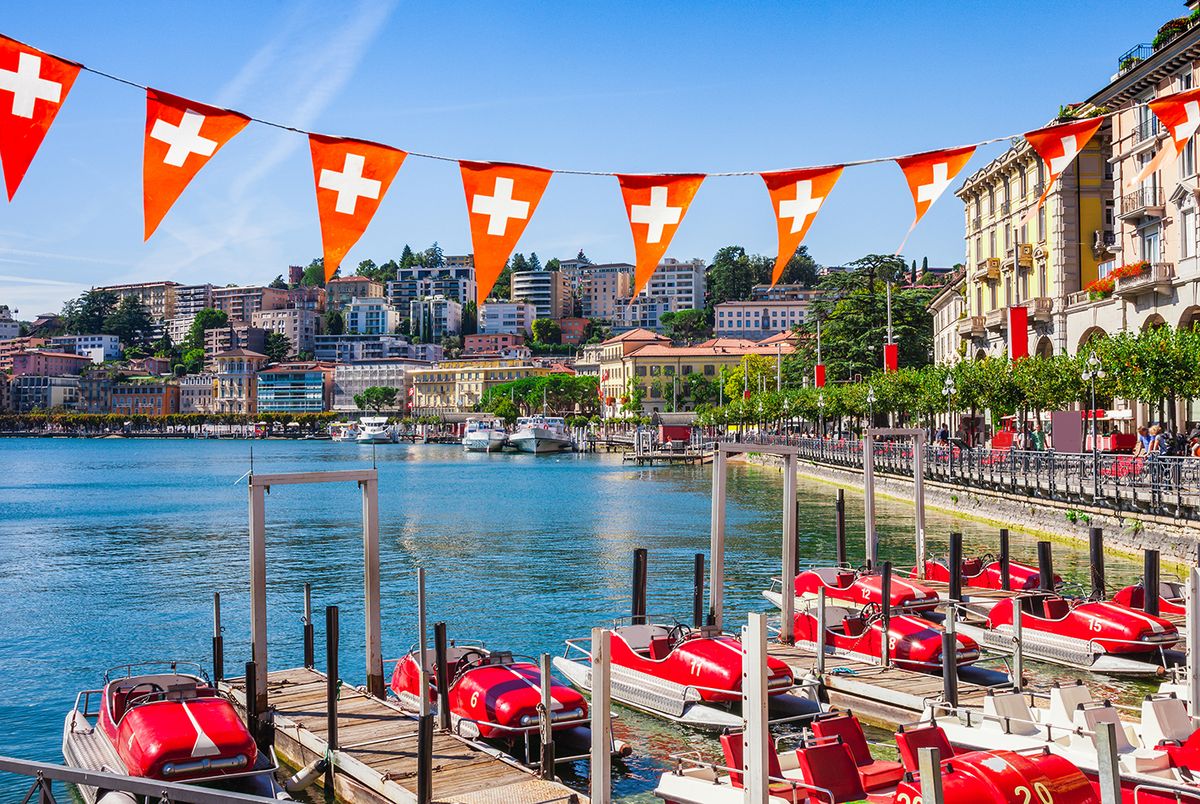 Panorama view of the lake Lugano, mountains and city Lugano, Ticino canton, Switzerland. Scenic beautiful Swiss town with luxury villas. Famous tourist destination in South Europe