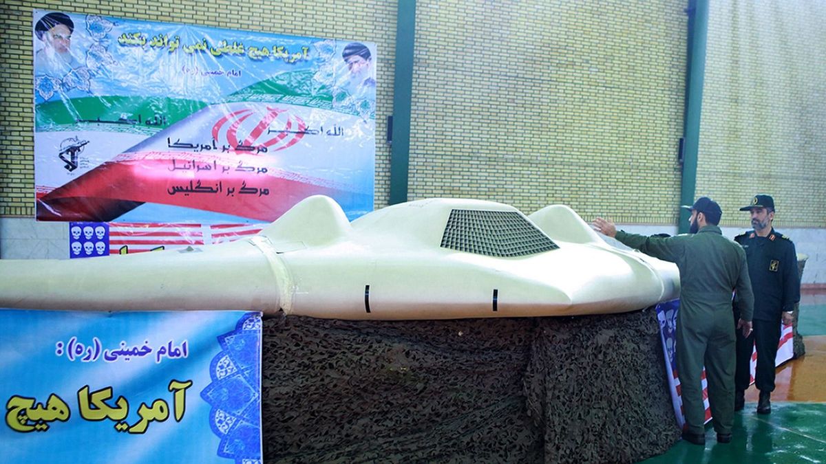 A picture released by the official website of Iran's Revolutionary Guards on December 8, 2011 shows Iranian Revolutionary Guard, Brigadier General Amir-Ali Hajizadeh (R) looking at what Iranian officials claim is the US RQ-170 Sentinel high-altitude reconnaissance drone that crashed in Iran on December 4, 2011 displayed at an undisclosed location. Revelations about the US reconnaissance drone suggest Washington is stepping up surveillance and pressure on the Islamic republic over its nuclear program, media reports say. Slogans on banner read in Farsi "Death to America, death to Israel, death to England." AFP PHOTO/HO/IRAN'S REVOLUTIONARY GUARD WEBSITERESTRICTED TO EDITORIAL USE - MANDATORY CREDIT " AFP PHOTO / IRAN'S REVOLUTIONARY GUARD WEBSITE" NO MARKETING NO ADVERTISING CAMPAIGNS - DISTRIBUTED AS A SERVICE TO CLIENTSEDS NOTE: AFP IS USING PICTURES FROM ALTERNATIVE SOURCES AS IT WAS NOT AUTHORISED TO COVER THIS EVENT, THEREFORE IT IS NOT RESPONSIBLE FOR ANY DIGITAL ALTERATIONS TO THE PICTURE'S EDITORIAL CONTENT, DATE AND LOCATION WHICH CANNOT BE INDEPENDENTLY VERIFIED == (Photo by IRAN'S REVOLUTIONARY GUARD WEBSI / AFP)