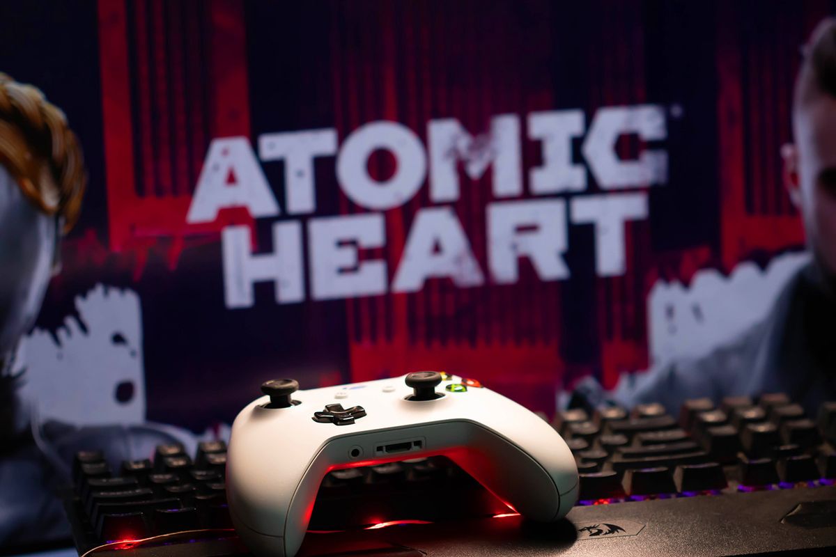 A,White,Xbox,Game,Controller,Lies,On,The,Keyboard,Against A white Xbox game controller lies on the keyboard against the background of the computer game Atomic Heart. Russia, Moscow, January 2023