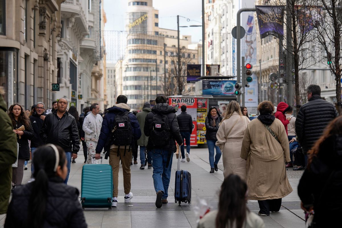 Tourists wheel luggage along the Gran Via in central Madrid, Spain, on Thursday, Dec. 29, 2022. The euro area faces a very difficult economic situation that will test individuals and businesses, European Central Bank Vice President Luis de Guindos said. 