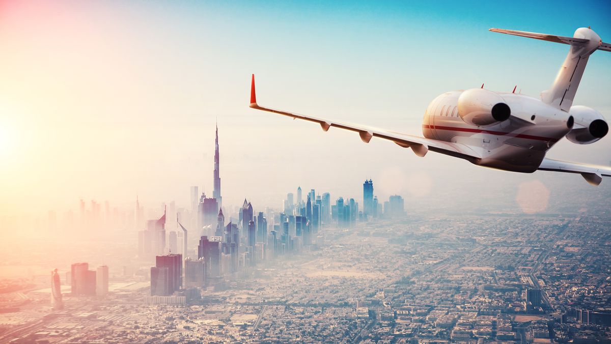 Private,Jet,Plane,Flying,Above,Dubai,City,In,Beautiful,Sunset